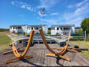 a couple of wooden chairs on a wooden deck at Domki GAMA in Gąski