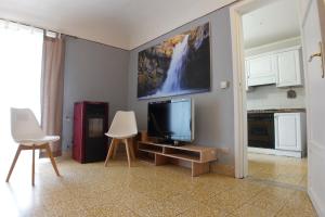 een woonkamer met een tv en 2 witte stoelen bij Exclusive Apartments in center in Mistretta