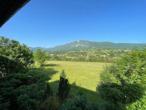 um campo de relva verde com uma montanha ao fundo em Studio au pied du Vercors em Saint-Jean-en-Royans