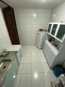a white kitchen with a sink and a refrigerator at Sol'Lar Pousada & Hostel in Fortaleza