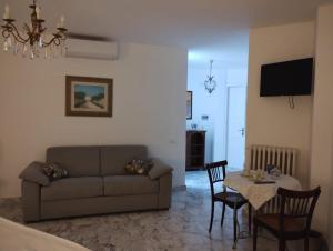 ein Wohnzimmer mit einem Sofa und einem Tisch mit Stühlen in der Unterkunft Il Giardino della Scuncerta in Lecce