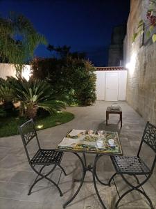 - une table et deux chaises sur la terrasse la nuit dans l'établissement Il Giardino della Scuncerta, à Lecce
