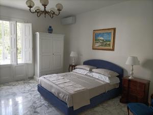 a bedroom with a blue bed and a chandelier at Il Giardino della Scuncerta in Lecce