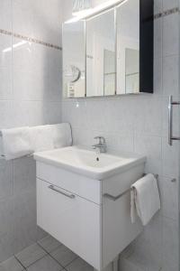 een witte badkamer met een wastafel en een douche bij Duen12_36 in Westerland