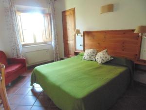 ein Schlafzimmer mit einem grünen Bett und einem roten Stuhl in der Unterkunft LaSelva in Albinia