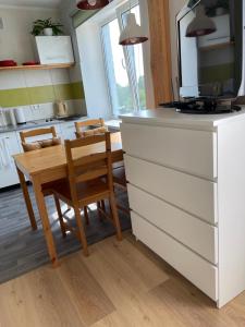 uma cozinha com uma mesa e duas cadeiras e um balcão em Mājīgs studio apartaments jūras pilsētā em Ventspils