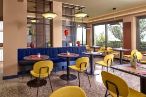 ein Restaurant mit Tischen und gelben Stühlen in der Unterkunft Residence Lido Hotel in Malcesine