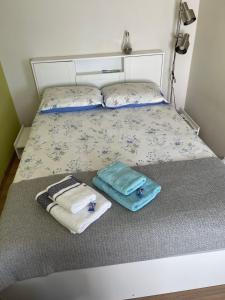 a bed with two towels and two pillows on it at Mājīgs studio apartaments jūras pilsētā in Ventspils