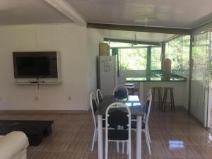 a living room with a table and chairs and a kitchen at Casa especial em Itacaré in Itacaré
