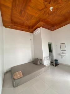 a bedroom with a bed with a wooden ceiling at Bara Village Guest House Bira in Bira