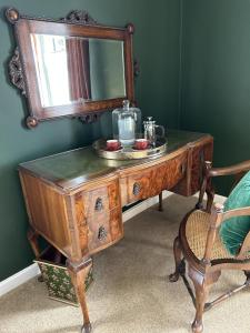 a dressing table with a mirror and a bowl of fruit on it at The Lodge at Salhouse in Norwich