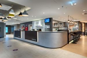 a restaurant with a counter with a bar in a room at Premier Inn Berlin City Wilmersdorf in Berlin
