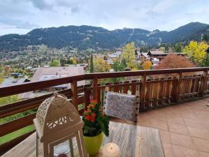 uma mesa e cadeiras numa varanda com vista em Le Bristol - Villars Bristol Apartments em Villars-sur-Ollon