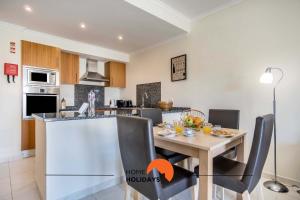 a kitchen and dining room with a table and chairs at #107 T1 Vista das Ondas by Home Holidays in Olhos de Água