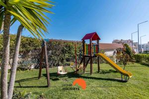 a playground with a slide in a yard at #107 T1 Vista das Ondas by Home Holidays in Olhos de Água