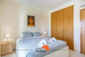 a bedroom with a bed and a wooden cabinet at #107 T1 Vista das Ondas by Home Holidays in Olhos de Água +47 photos