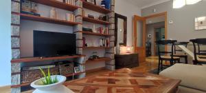 a living room with a flat screen tv on a brick wall at LA ERMITA in Zamora