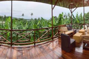 um quarto com uma varanda com vista para um milheiral em Ubá Budo Praia - Villa em São Tomé