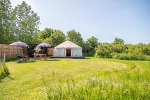 a yurt in a field with a fence and trees at Luxury glamping in Constable Country - Valley View Yurt 