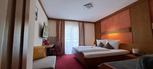 um quarto de hotel com duas camas e uma secretária em Haus Tirol Appartements em Ried im Oberinntal