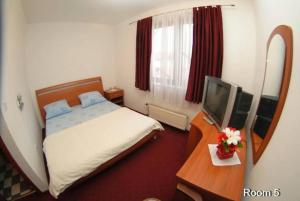um quarto de hotel com uma cama e uma televisão em Motel Bella Italia em Saraievo