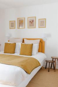 Ferme des Goupillières في مايسونز: غرفة نوم بسريرين مع شراشف بيضاء ومخدات صفراء