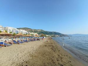 einen Strand mit Stühlen und Sonnenschirmen und dem Wasser in der Unterkunft TreA Accomodations - Despacito TRB Sea View in Vlorë