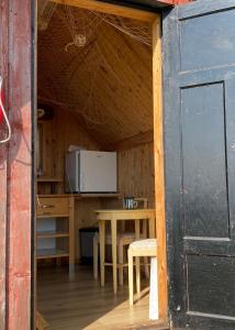 a room with a kitchen and a table and a door at Aspö Glamping in Drottningskär
