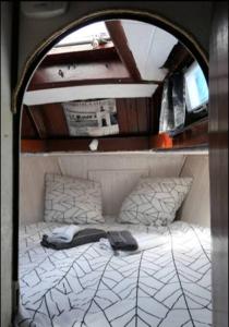 Una cama pequeña en una habitación pequeña en un barco en Bateau Watson, vivez l'aventure en Ouistreham