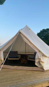 a canvas tent with two chairs and a table at Aspö Glamping in Drottningskär