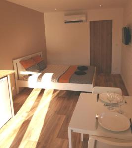 Habitación pequeña con cama, mesa y sidra de mesa en La clé des vignes, en Saint-Médard-dʼEyrans