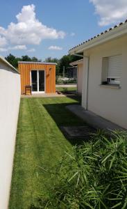 a yard with a wooden fence and a house at La clé des vignes in Saint-Médard-dʼEyrans