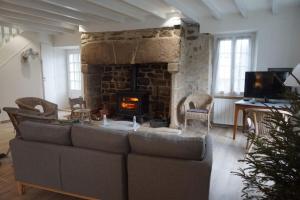 uma sala de estar com um sofá e uma lareira em Le clos du 10 em Treignac
