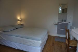 a small bedroom with a bed and a kitchen at Le clos du 10 in Treignac