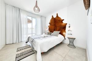 Schlafzimmer mit einem Bett mit einem großen Kopfteil aus Holz in der Unterkunft Pachamama House - Near the beach, Air-Con, Fast Wifi and SAT tv By Lanzarote Vacation Homes in Playa Blanca