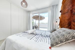 a white bedroom with a bed and a large window at Pachamama House-near the beach, fast wifi, air-con and SAT tv in Playa Blanca