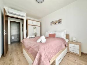 a bedroom with a large bed with a pink blanket at Premium Apartment by Hi5 - Zamardi One-bedroom in Zamárdi