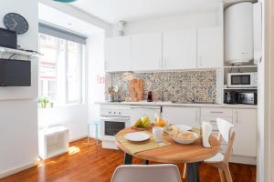 a kitchen with a table with a bowl of fruit on it at Lisbon Mouraria Apartment in Lisbon