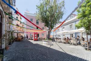 a street with flags and people sitting at tables at Lisbon Mouraria Apartment in Lisbon +21 photos