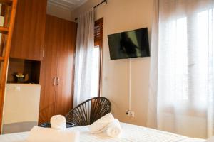 a bedroom with a bed and a tv on the wall at Koletti 7 in Nafplio
