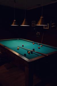 a dark room with a pool table with balls on it at Åsby Hotell in Hallstahammar