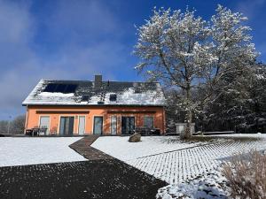 una casa con nieve en el suelo delante de ella en Phil, en Malchow