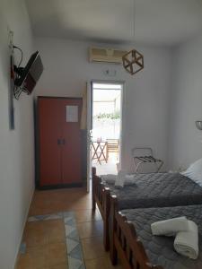 Schlafzimmer mit einem Bett und einer Tür zu einer Terrasse in der Unterkunft Elzahed apartments orza in Kimolos
