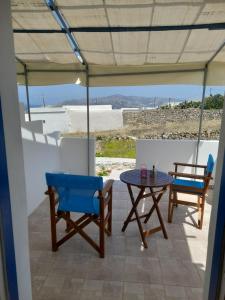 eine Terrasse mit 2 Stühlen und einem Tisch in der Unterkunft Elzahed apartments orza in Kimolos