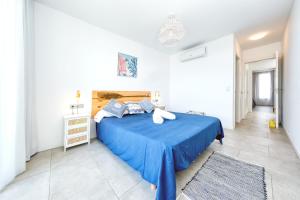 a bedroom with a blue bed with a blue blanket at La Marinera House - Near the beach, Air-Con, Fast Wifi and SAT tv By Lanzarote Vacation Homes in Playa Blanca