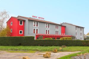 un hotel con un edificio rojo y blanco en Enzo Hotels Pont-a-Mousson by Kyriad Direct, en Pont-à-Mousson