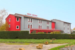 ein Hotel mit einem roten und weißen Gebäude in der Unterkunft Enzo Hotels Pont-a-Mousson by Kyriad Direct in Pont-à-Mousson