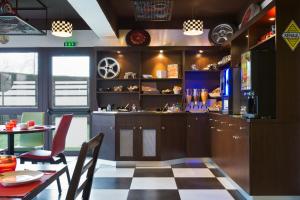 uma cozinha com piso em xadrez e uma mesa com cadeiras em Enzo Hotels Pont-a-Mousson by Kyriad Direct em Pont-à-Mousson