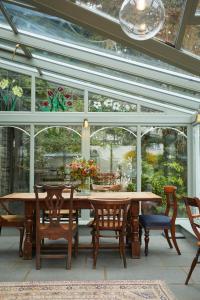 a conservatory with a wooden table and chairs at Victorian House in Grasmere