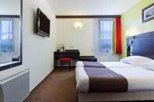 a hotel room with two beds and a television at Enzo Hotels Pont-a-Mousson by Kyriad Direct in Pont-à-Mousson